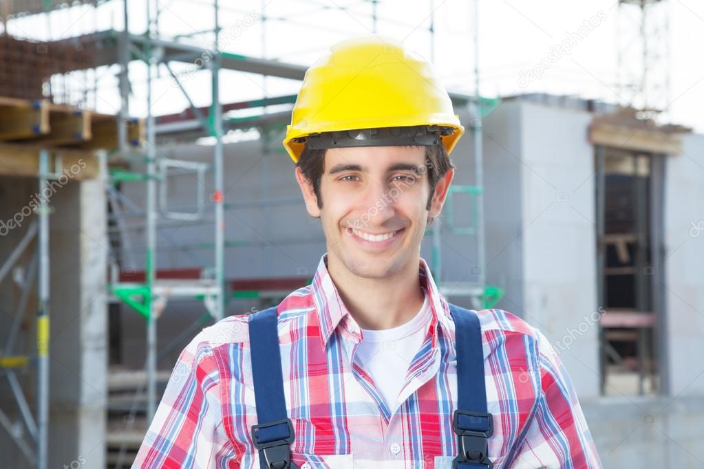 Laughing hispanic construction worker at building site