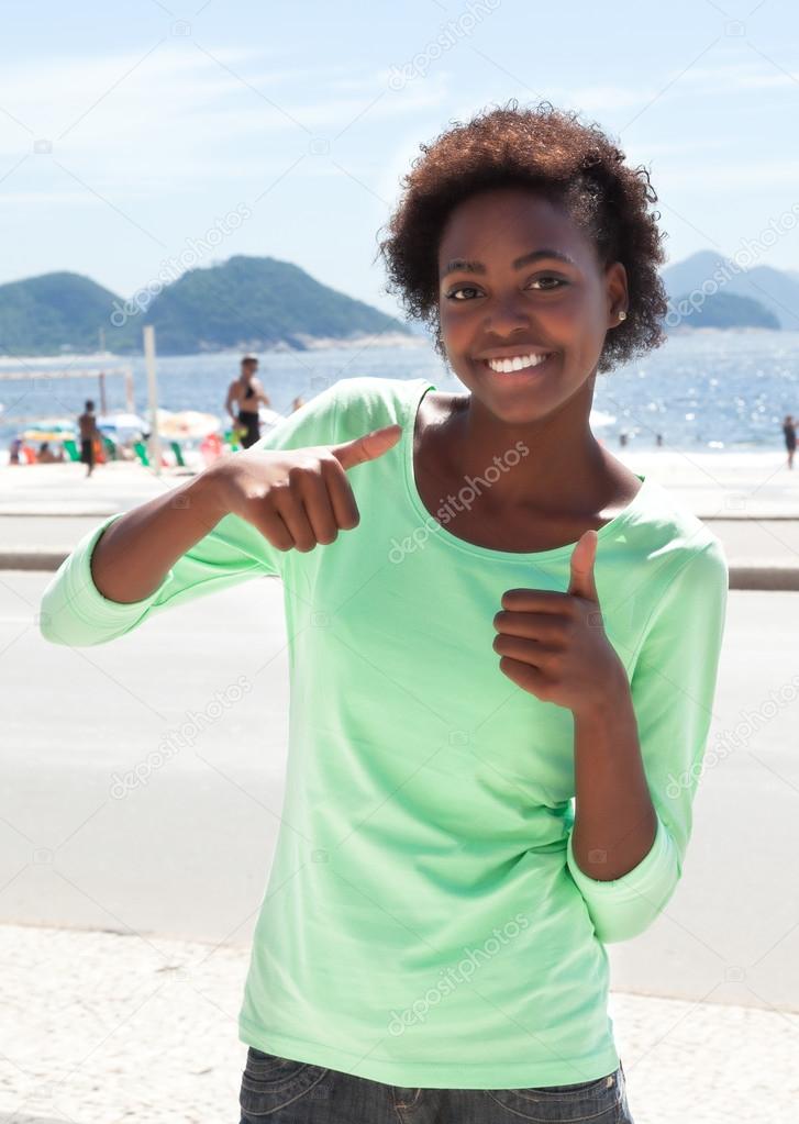 Brazilian woman at Copacabana beach showing thumbs