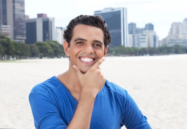 Laughing guy in a blue shirt with cityscape in the background — Stock Photo, Image