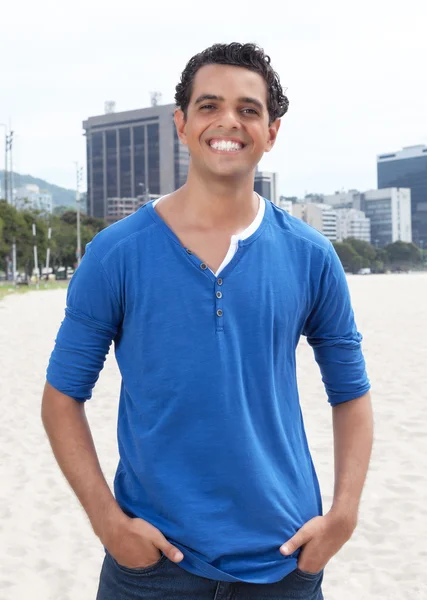 Attractive guy in a blue shirt with cityscape in the background — Stock Photo, Image
