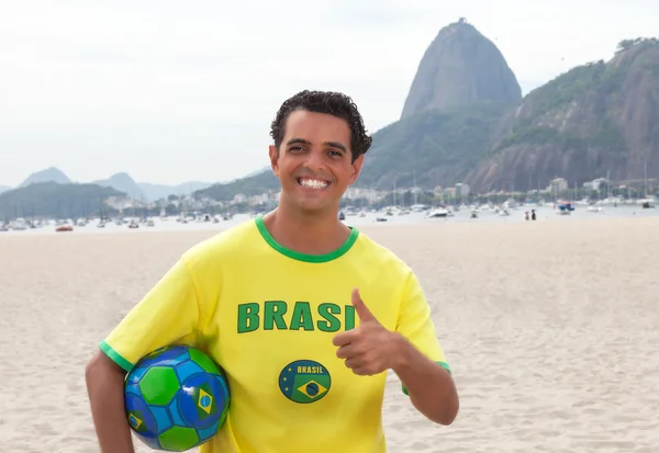 Ventilador esportivo brasileiro com bola no Rio de Janeiro mostrando polegar — Fotografia de Stock