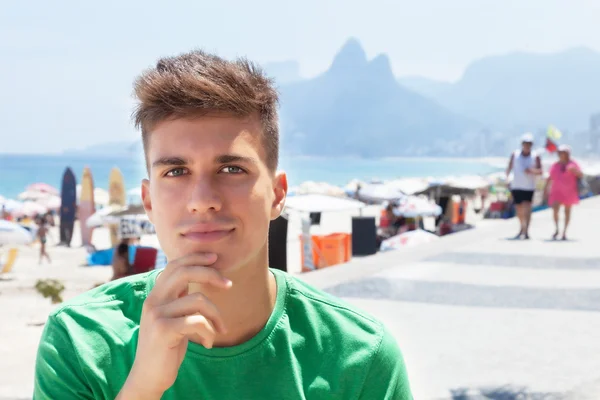 Sportig kille i en grön skjorta på stranden i Brasilien — Stockfoto