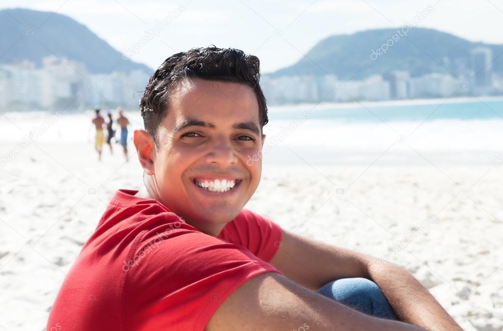Happy latin guy at beach looking at camera