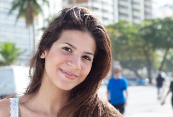 Lachende vrouw met donker haar in de stad — Stockfoto