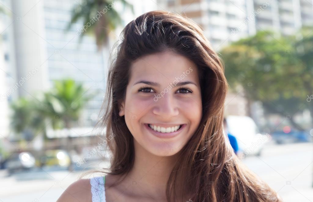 Portrait of a laughing woman with dark hair in the city