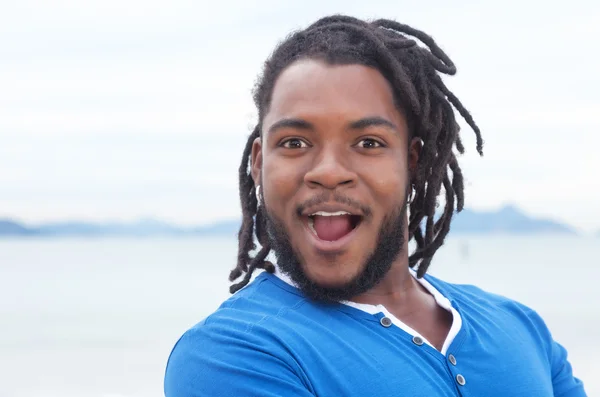 Feliz chico afroamericano con rastas en la playa — Foto de Stock