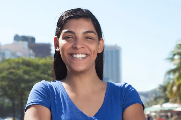 Femme latine avec de longs cheveux foncés dans la ville regardant la caméra — Photo