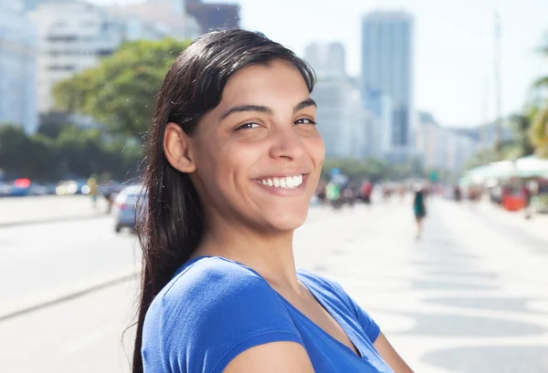 Gelukkig Latijns-vrouw met lang donker haar in de stad — Stockfoto