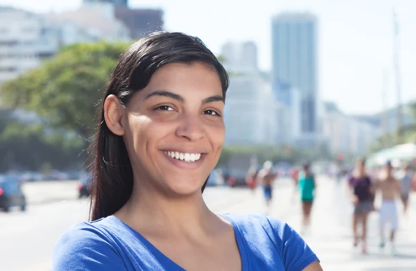 Смеющаяся латиноамериканка с длинными темными волосами в городе — стоковое фото