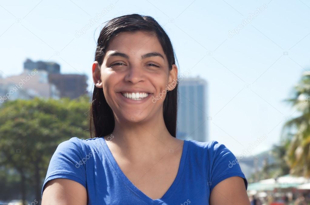 Latin woman with long dark hair in the city looking at camera