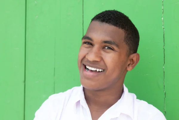 Szczęśliwy facet Karaibów przed zielony ściana — Zdjęcie stockowe