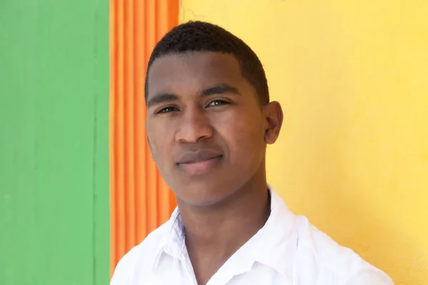 Joven caribeño frente a una pared colorida — Foto de Stock