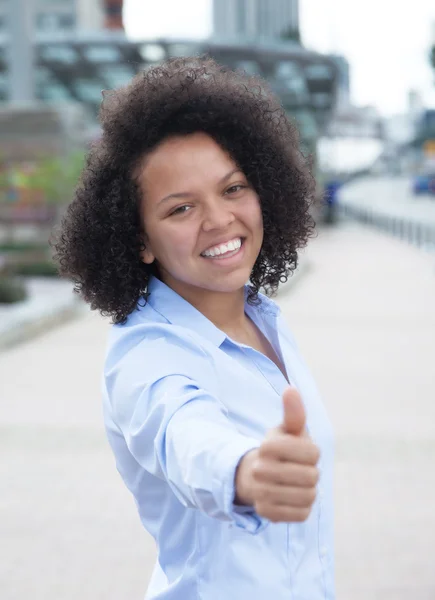 Skrattande afroamerikanska kvinna i staden visar tummen — Stockfoto