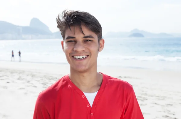 Jóképű spanyol srác keresi a kamera strandon — Stock Fotó