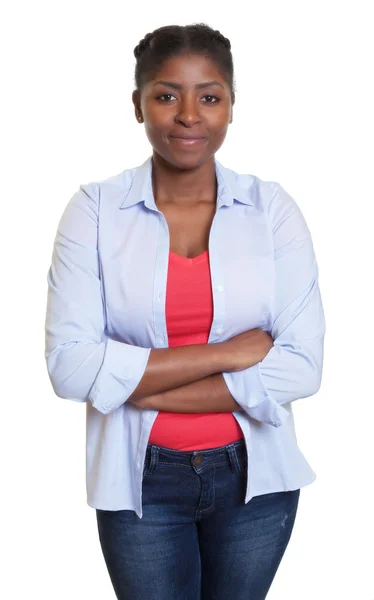 Mujer africana sonriente con jeans y brazos cruzados —  Fotos de Stock