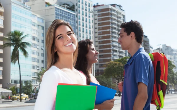 Skrattande kvinnlig student med två vänner — Stockfoto