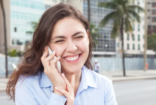 一件蓝色的衬衫在电话中城市幸福的女人 — 图库照片