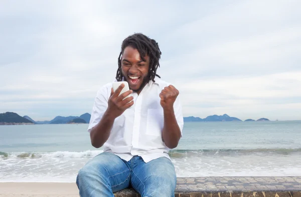 Africano americano cara com dreadlocks e camisa branca recebendo g — Fotografia de Stock