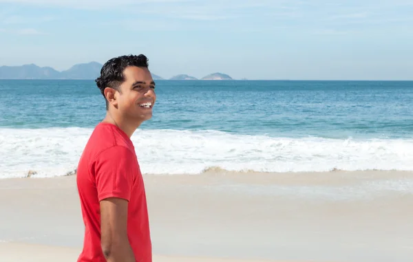 Lachen Latijns-man lopen op strand — Stockfoto