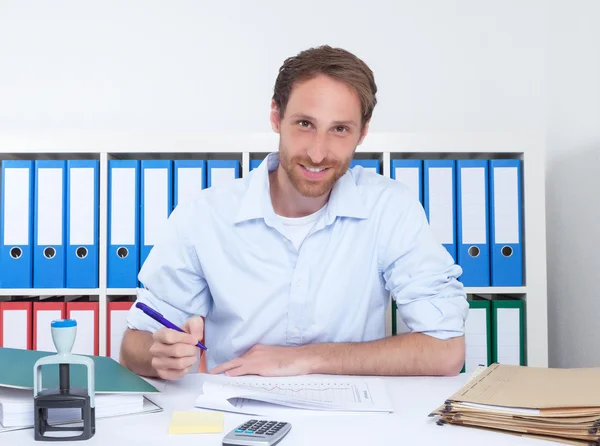 German businessman at office writing note — Stock Photo, Image
