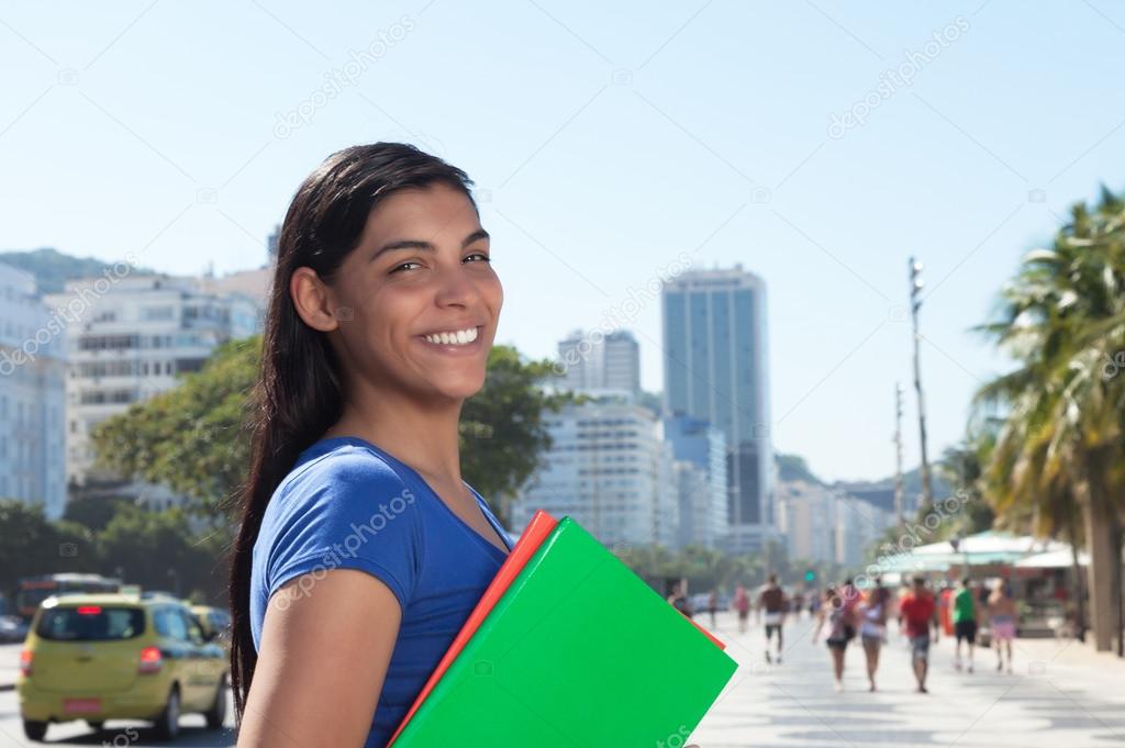 Happy latin student with long dark hair in the city