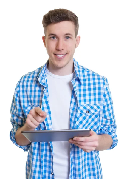 Un tipo con una camisa a cuadros escribiendo un mensaje en la tableta —  Fotos de Stock