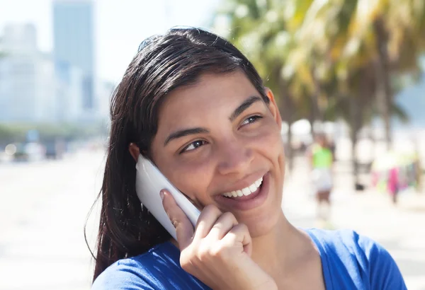 Attraktive lateinamerikanische Frau mit langen dunklen Haaren am Telefon in der Stadt — Stockfoto