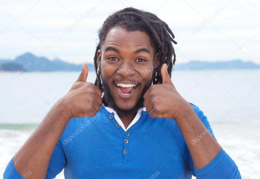 Funny african american guy with dreadlocks at beach