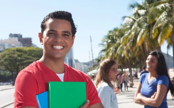 Latin male student with friends in the city — Stock Photo, Image