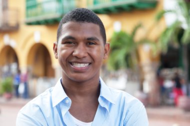 Happy guy in a blue shirt in a colorful colonial town clipart