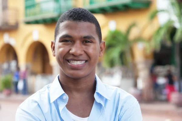 Happy guy in a blue shirt in a colorful colonial town — Stock Photo, Image