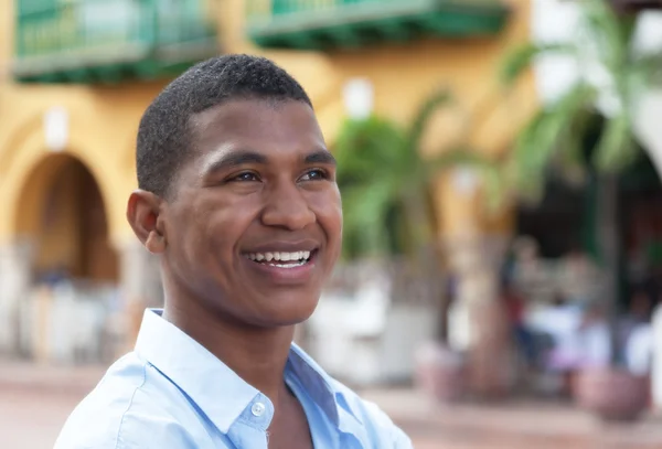 Dreaming guy in a blue shirt in a colorful colonial town — Stock Photo, Image