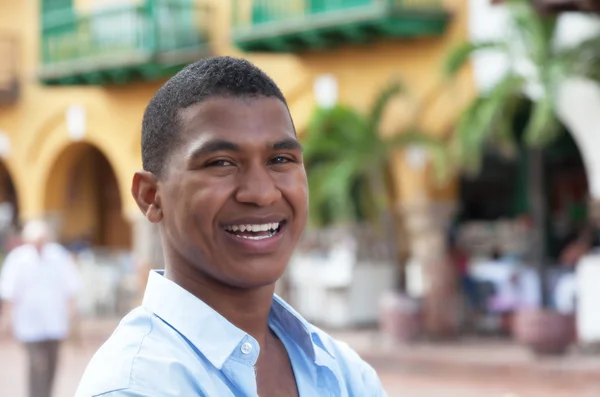 Rindo cara em uma camisa azul em uma cidade colonial colorida — Fotografia de Stock