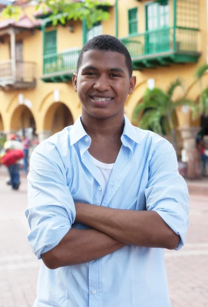 Beau mec en chemise bleue dans une ville coloniale colorée — Photo