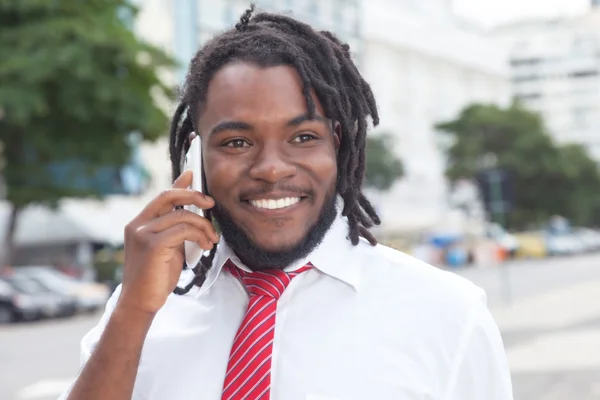 African american businessman with dreadlocks at phone in the cit — Stock Photo, Image