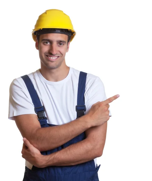 Happy latin construction worker pointing sideways — Stock Photo, Image