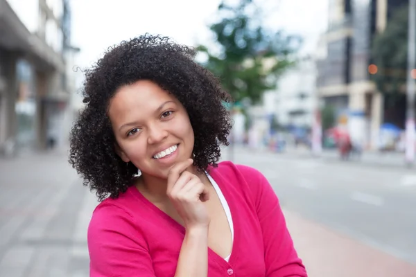 Młody african american kobieta w różowej koszuli w mieście — Zdjęcie stockowe