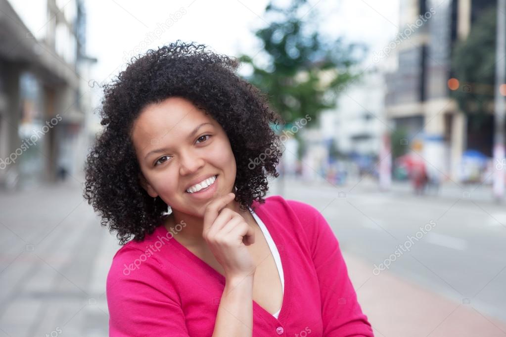 Young african american woman in pink shirt in the city