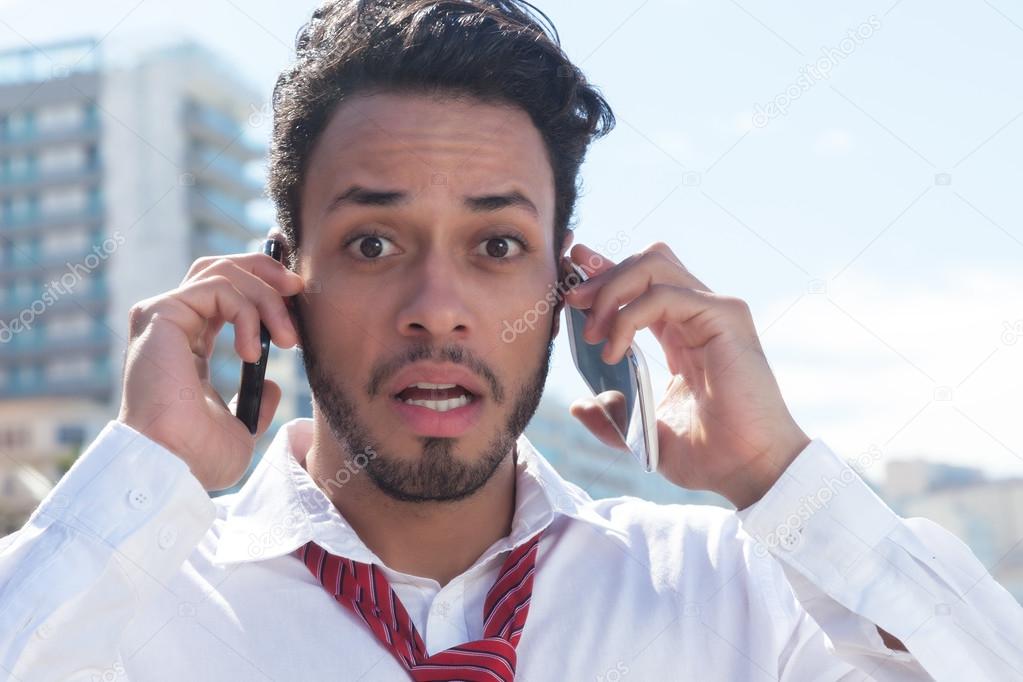 Handsome businessman on two phones