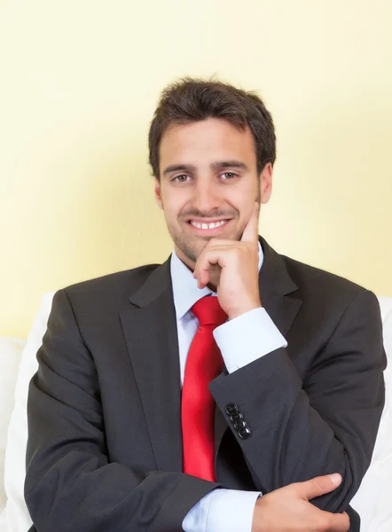 Vilande latin affärsman med kostym och röd slips — Stockfoto
