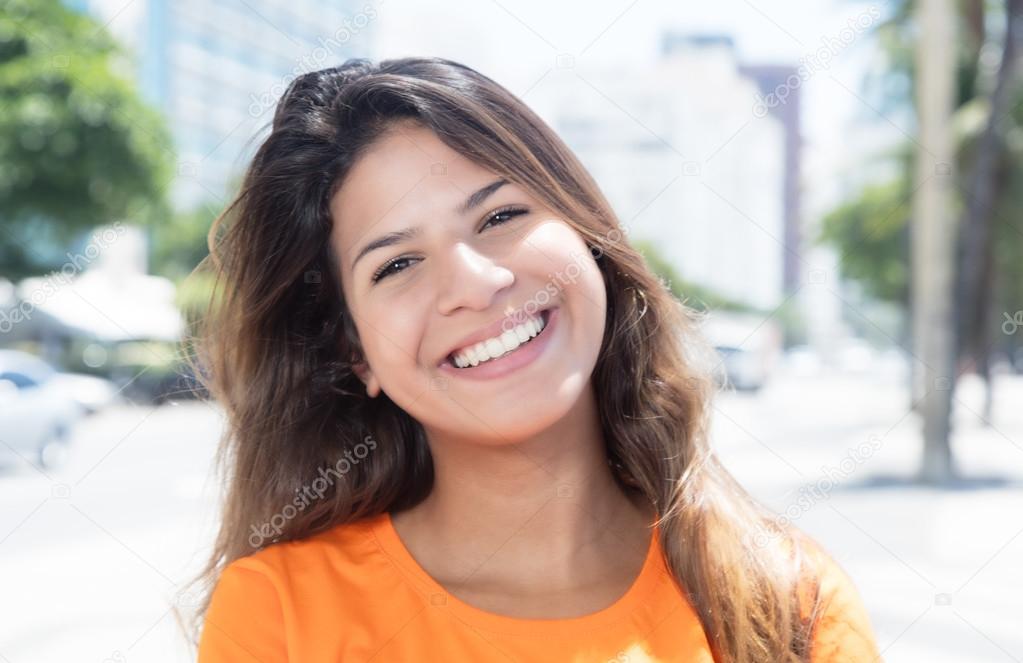 Laughing caucasian woman in a orange shirt in the city