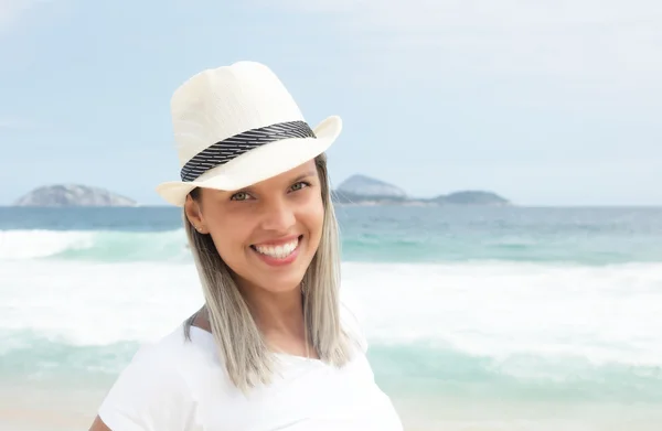 Riendo mujer caucásica con sombrero en la playa —  Fotos de Stock