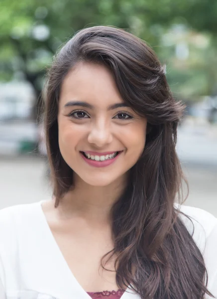 Portret van een vrouw met witte blouse in een park — Stockfoto