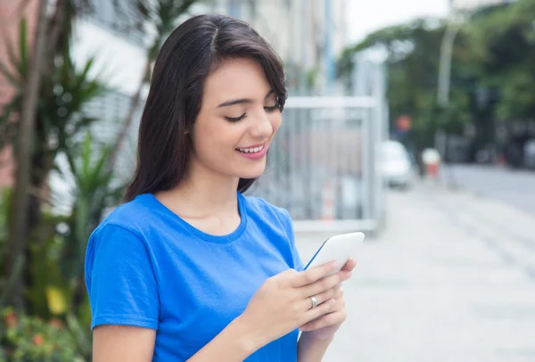 Καυκάσιος κορίτσι με μπλε πουκάμισο χρησιμοποιώντας wifi με τηλέφωνο — Φωτογραφία Αρχείου