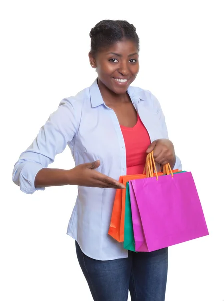 Happy african woman presenting her shopping bags — Stock Photo, Image