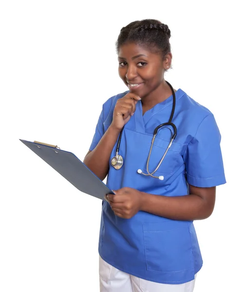 Afrikanische Krankenschwester mit Klemmbrett blickt in Kamera — Stockfoto