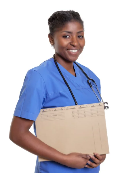 Infirmière africaine rieuse avec dossier d'un patient — Photo