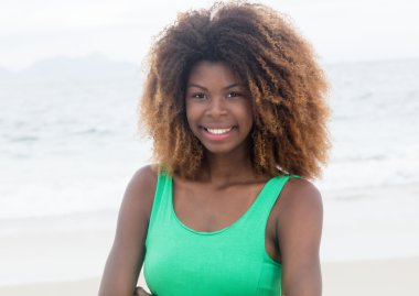 Çılgın saç modeli ile yeşil elbiseli mutlu Brezilyalı kız