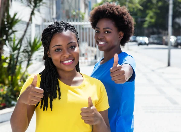 Duas namoradas afro-americanas mostrando o polegar para cima — Fotografia de Stock