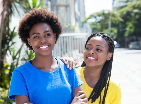 Two african american girlfriends laughing in the city — Stock Photo, Image